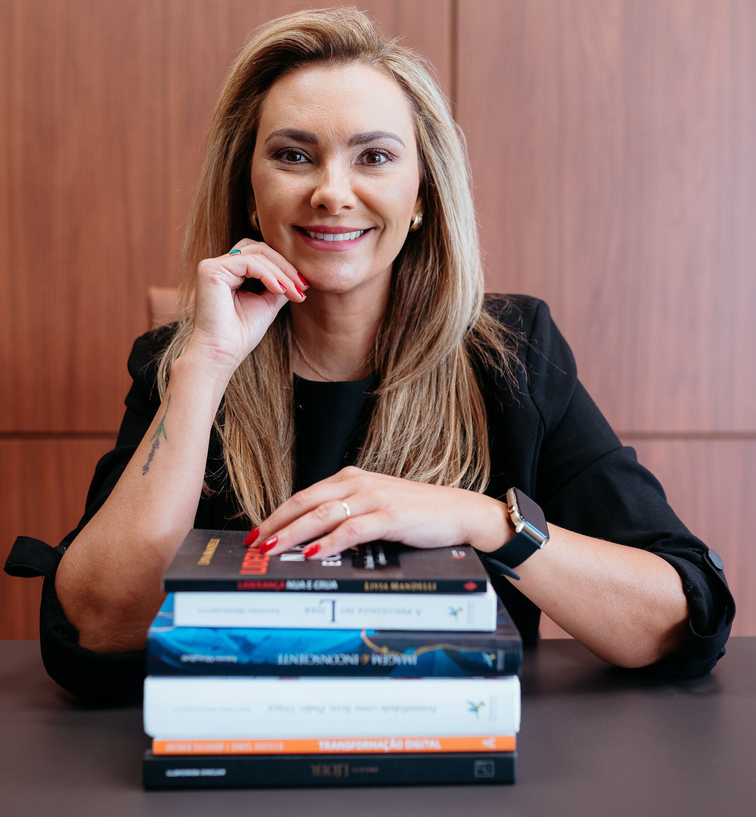 Mari Dias com livros sobre desenvolvimento e liderança